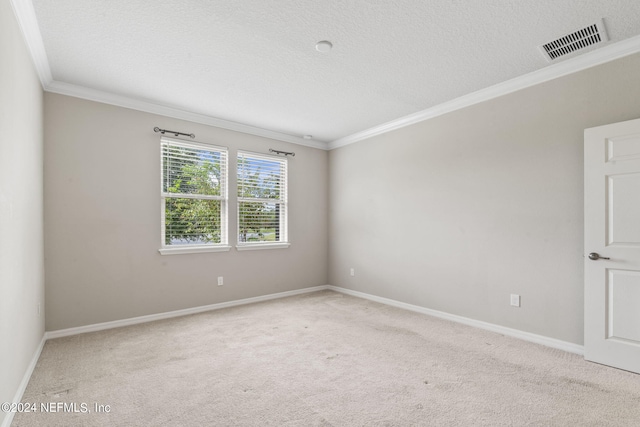 empty room with ornamental molding, a textured ceiling, and light colored carpet