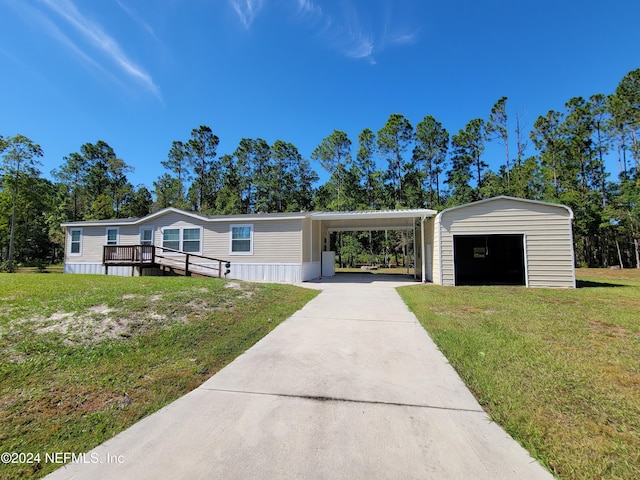 manufactured / mobile home with a wooden deck, a front yard, and an outbuilding