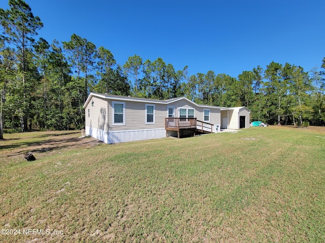 view of front of home with a front yard and a wooden deck