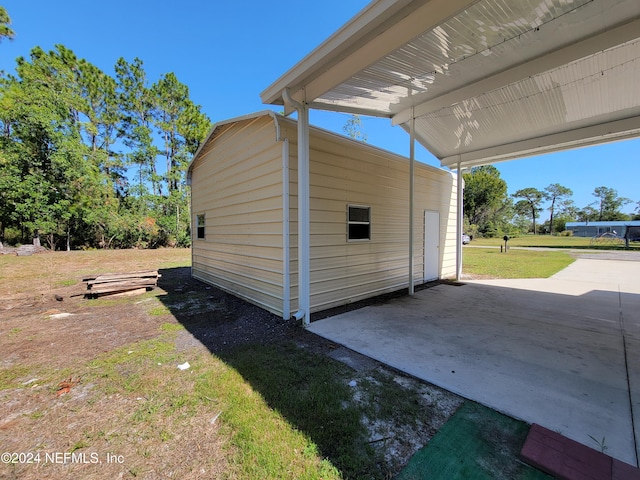 exterior space with a patio area, a yard, and a carport