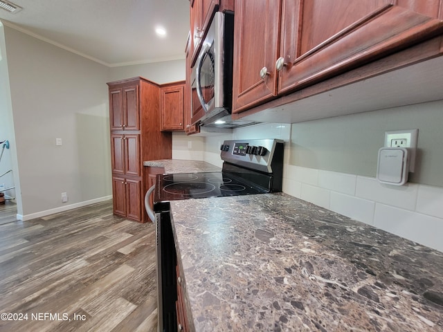 kitchen with crown molding, stainless steel appliances, and hardwood / wood-style floors