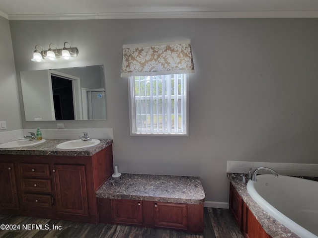 bathroom featuring vanity, a relaxing tiled tub, hardwood / wood-style floors, and ornamental molding