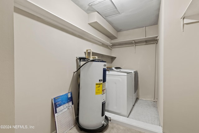 washroom with electric water heater and washing machine and clothes dryer