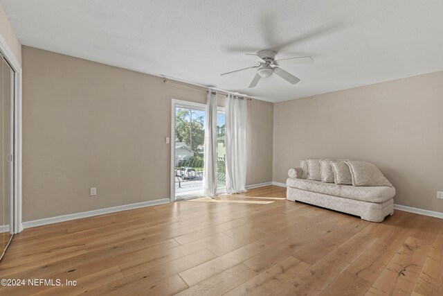 sitting room with ceiling fan, a textured ceiling, and light wood-type flooring