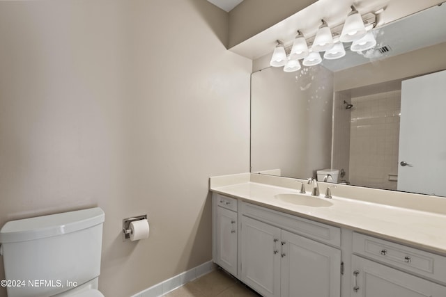 bathroom with vanity, toilet, tile patterned floors, and a tile shower