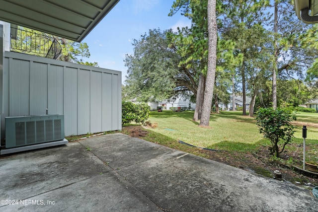 view of yard with central air condition unit and a patio area