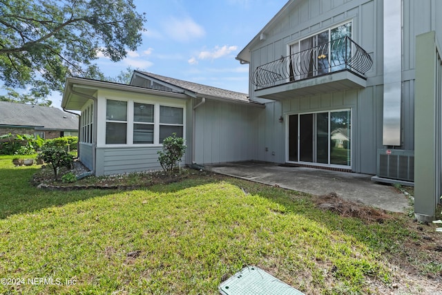 back of property with a patio area, a yard, and a balcony