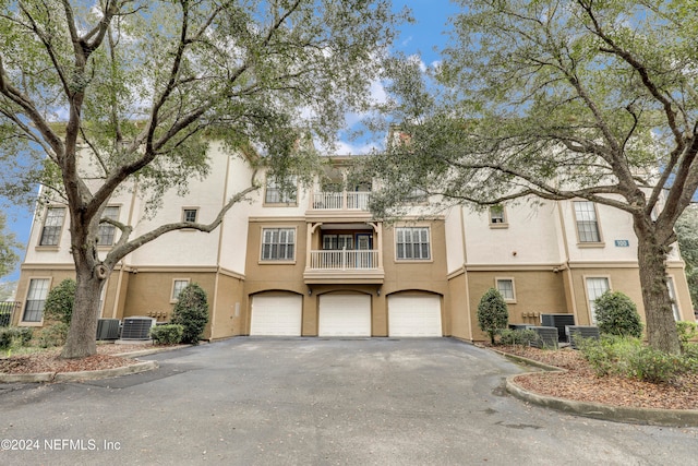 view of front of house with cooling unit, a balcony, and a garage