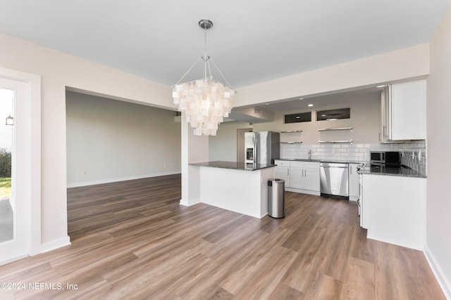 kitchen featuring stainless steel appliances, decorative light fixtures, dark hardwood / wood-style flooring, and white cabinets