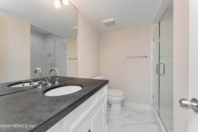 bathroom featuring toilet, a shower with shower door, and vanity