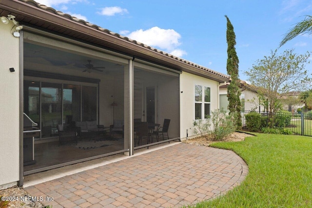 rear view of property with a yard, a patio area, and ceiling fan