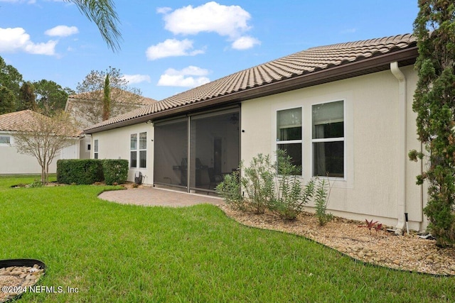 back of house with a patio and a lawn