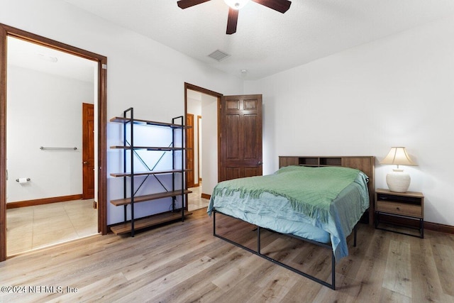 bedroom featuring light hardwood / wood-style floors, a textured ceiling, and ceiling fan