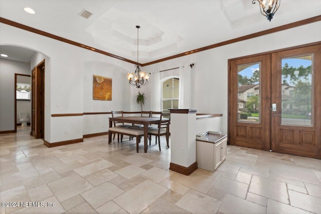 dining area featuring french doors, ornamental molding, and a chandelier