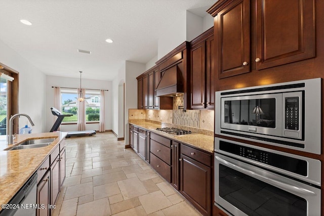 kitchen featuring light stone countertops, stainless steel appliances, sink, and custom range hood