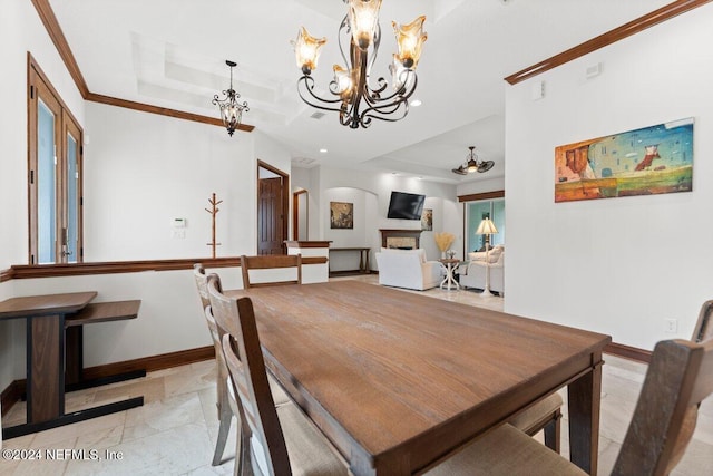 dining area with crown molding, a notable chandelier, and a tray ceiling