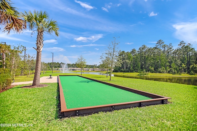 view of home's community with a water view and a lawn