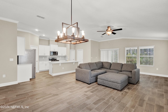 living room featuring sink, ceiling fan with notable chandelier, vaulted ceiling, crown molding, and light hardwood / wood-style flooring