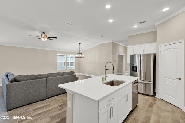 kitchen featuring a center island with sink, sink, white cabinetry, and stainless steel appliances