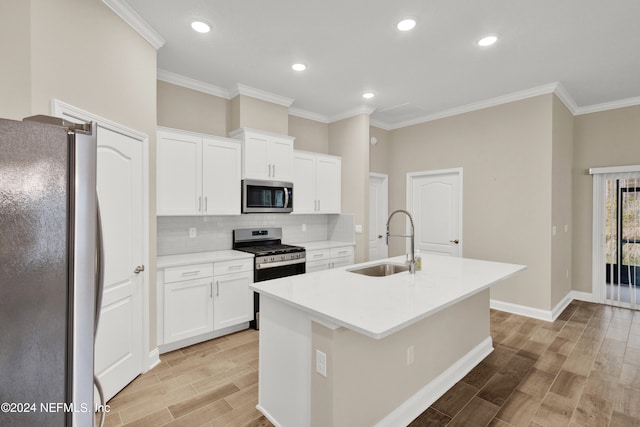 kitchen featuring white cabinetry, stainless steel appliances, sink, and a center island with sink