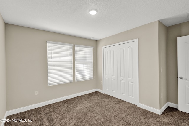 unfurnished bedroom featuring a closet, carpet floors, and a textured ceiling