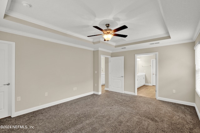 unfurnished bedroom featuring crown molding, ceiling fan, ensuite bath, and a raised ceiling