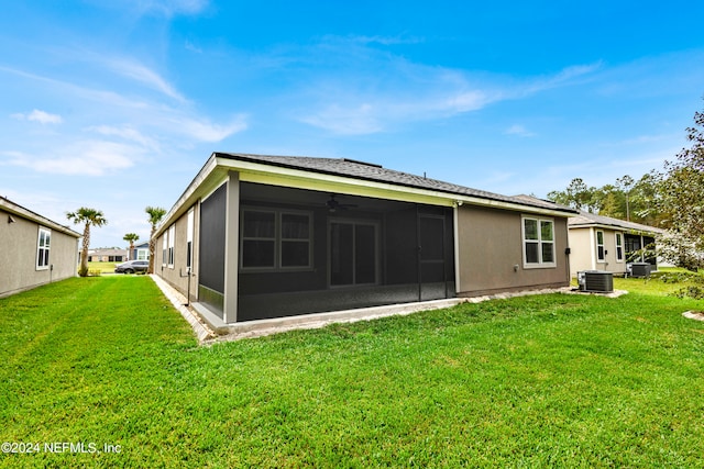 rear view of house featuring cooling unit, a sunroom, a lawn, and ceiling fan