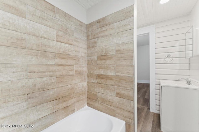 bathroom featuring vanity, hardwood / wood-style floors, and wood walls