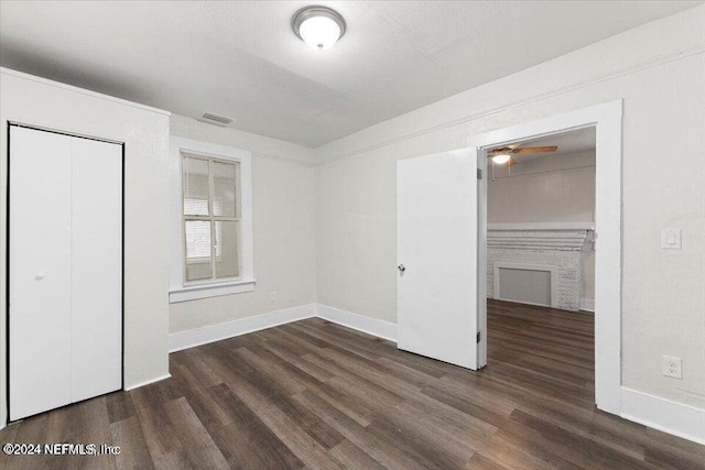 unfurnished bedroom featuring dark wood-type flooring and a closet