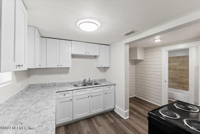 kitchen featuring sink, dark hardwood / wood-style flooring, white cabinets, light stone counters, and range with electric stovetop