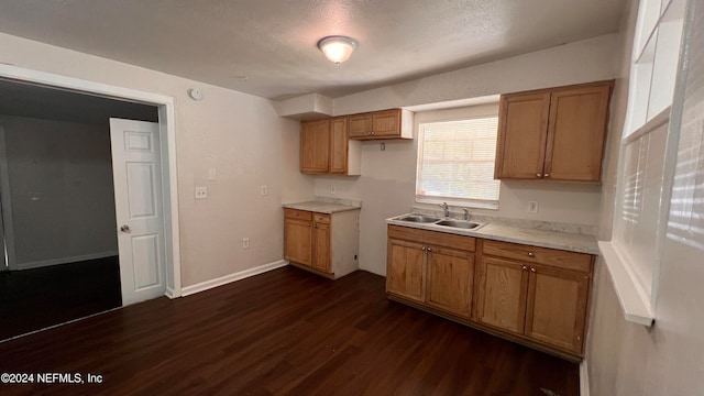 kitchen featuring sink, dark wood-type flooring, and a textured ceiling