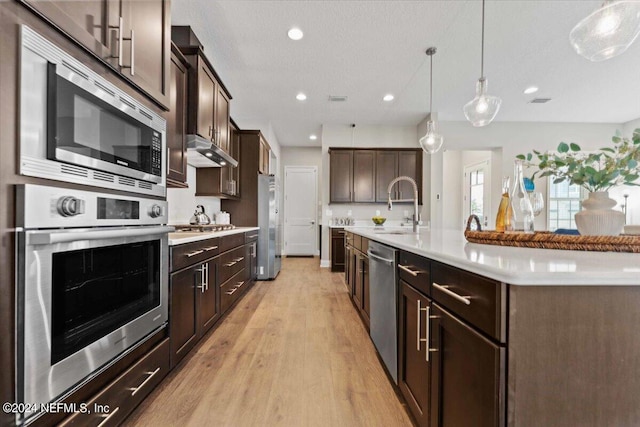 244 Rum Runner Way, Saint Johns, FL 32259 - kitchen with appliances with stainless steel finishes, a sink, light countertops, light wood-style flooring, and dark brown cabinets
