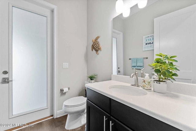 bathroom featuring vanity, toilet, and hardwood / wood-style flooring