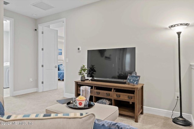 living room featuring washer / dryer and light colored carpet