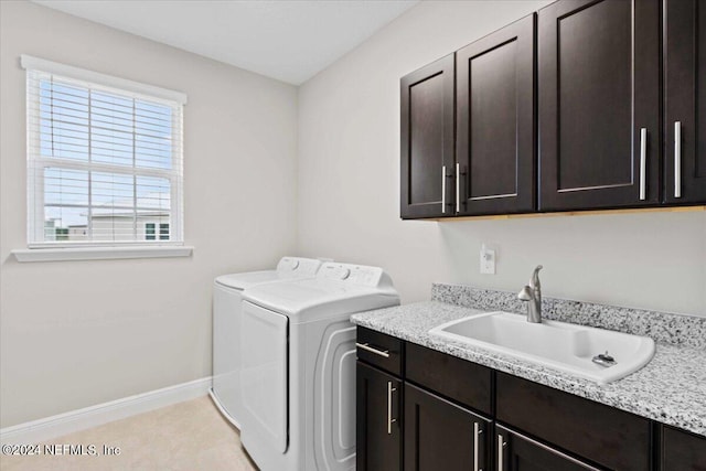 clothes washing area featuring sink, independent washer and dryer, and cabinets