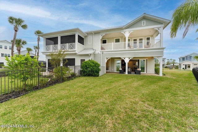 back of property with a patio area, a yard, and a balcony