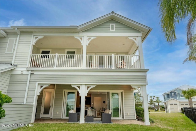 rear view of house with a yard, a patio, and a balcony