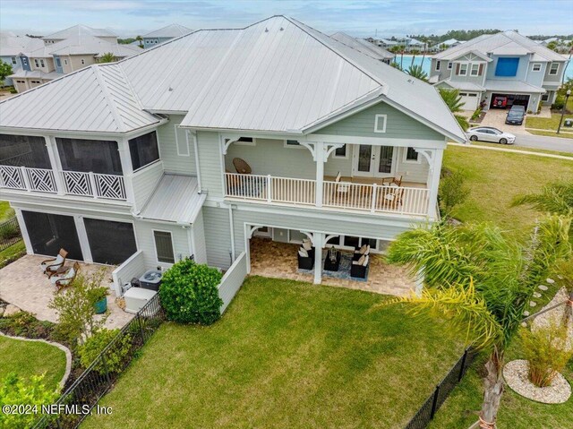 244 Rum Runner Way, Saint Johns, FL 32259 - back of house featuring a yard, metal roof, a garage, a patio area, and a residential view