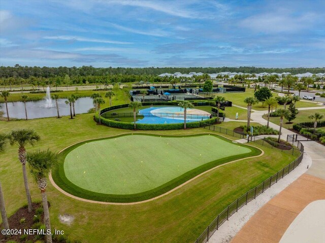 view of property's community featuring a water view, a lawn, and a swimming pool