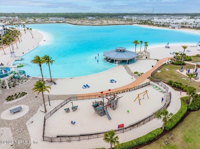 drone / aerial view featuring a water view and a view of the beach