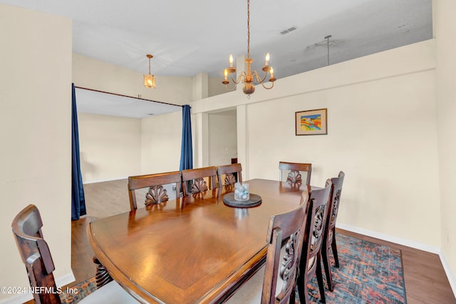 dining area featuring wood-type flooring and an inviting chandelier