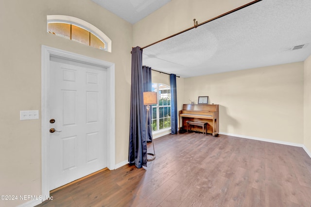 foyer entrance with hardwood / wood-style flooring and a textured ceiling