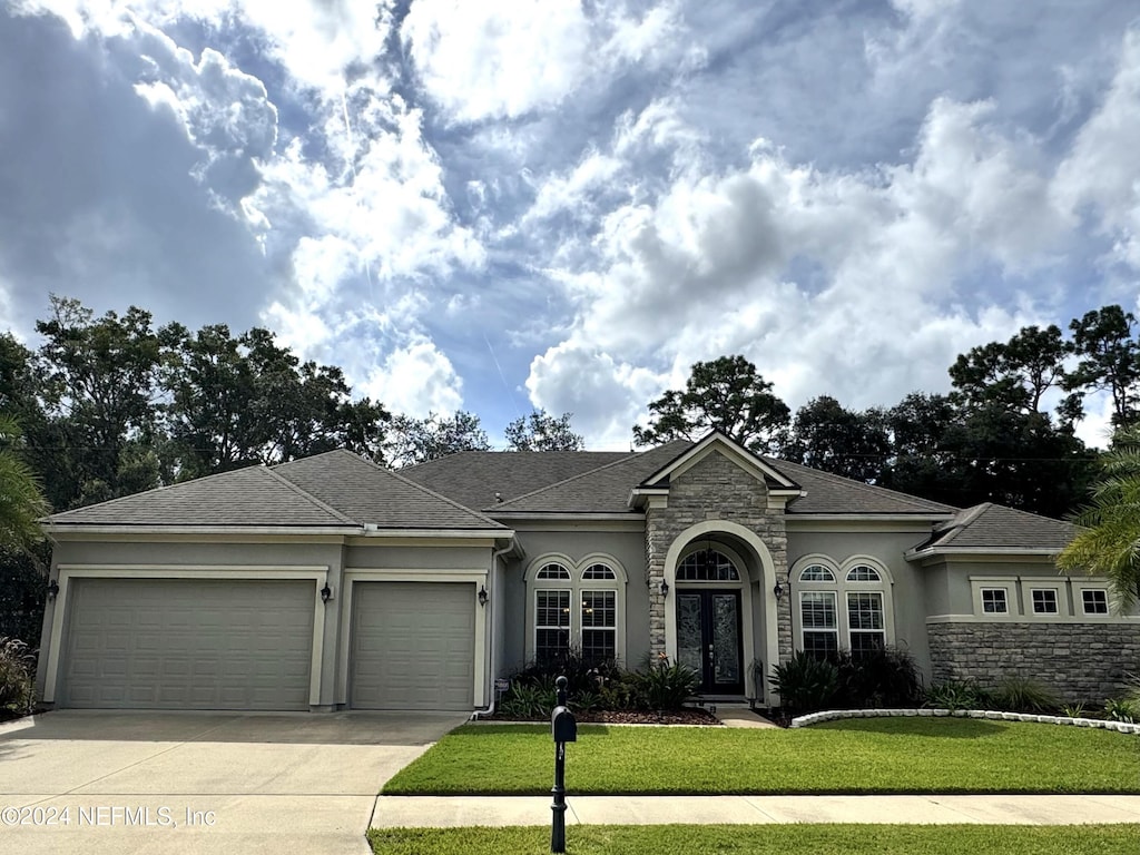 view of front of house featuring a front yard and a garage