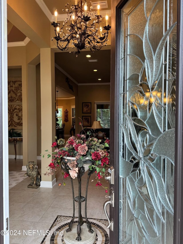 tiled foyer entrance featuring crown molding and an inviting chandelier