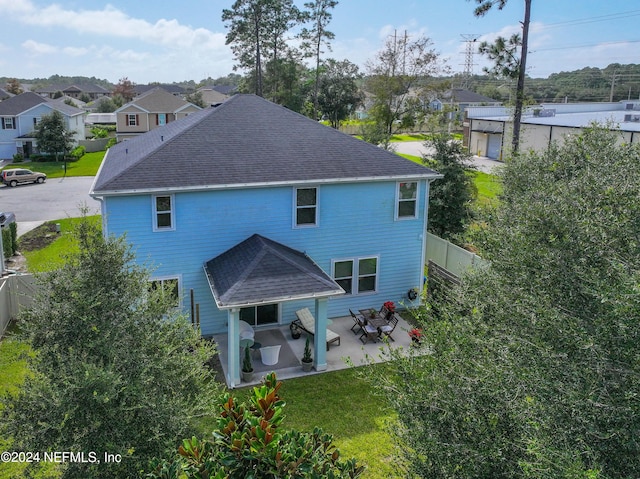 back of property with a patio and a lawn