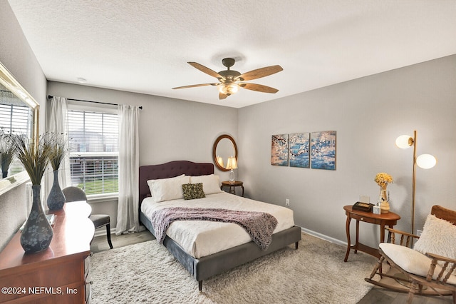 bedroom featuring ceiling fan and a textured ceiling