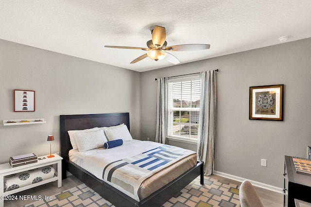 bedroom featuring ceiling fan and a textured ceiling