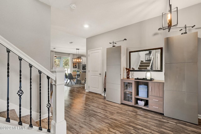 interior space with a notable chandelier, a barn door, and wood-type flooring