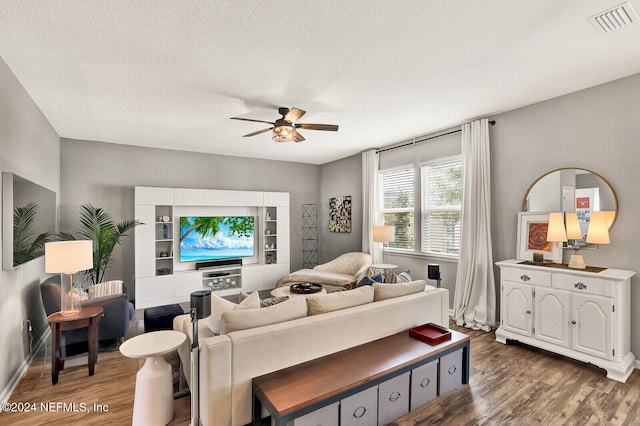 living room with a textured ceiling, hardwood / wood-style flooring, and ceiling fan