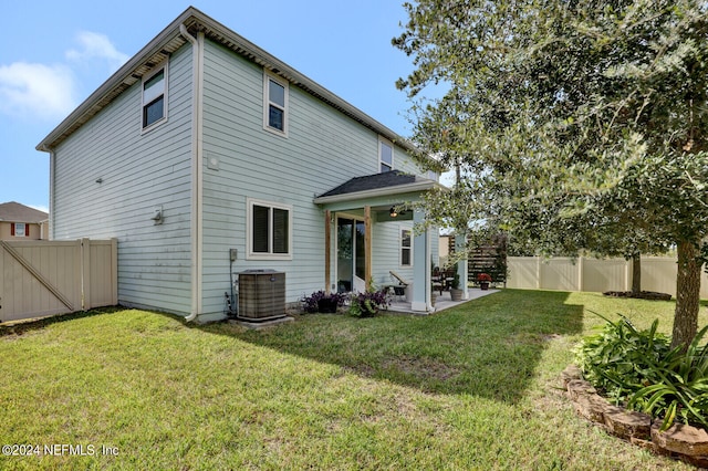 rear view of house featuring a yard, a patio, and cooling unit